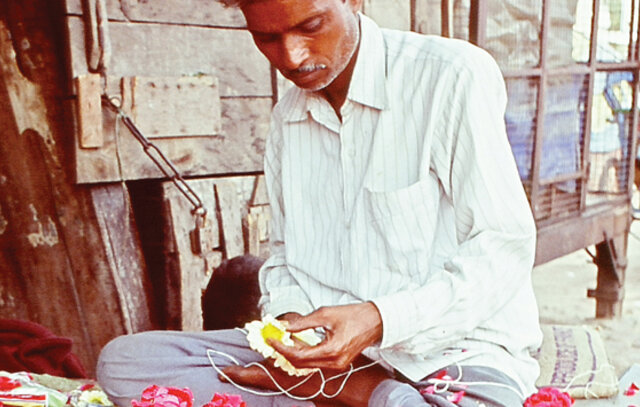 man sitting, doing his craft